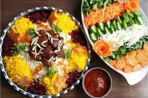 Gheymeh nesar in a copper tray with salad