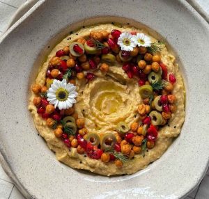 Easy hummus recipe with olive and flower decoration