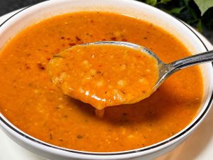 Easy Ezogelin soup served in a bowl with fresh lemon wedges.