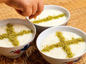 Traditional Shir Berenj (Persian rice pudding) with creamy texture, rose water, and crushed pistachios.