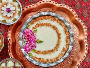 Freshly made Shir Berenj recipe garnished with almonds, pistachios, and edible rose petals.