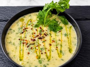 Homemade creamy celery soup served with fresh celery leaves