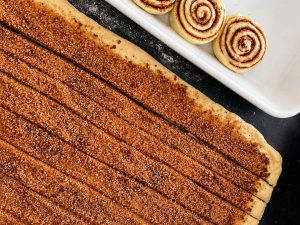 Fluffy cinnamon rolls baking in a rectangular baking dish
