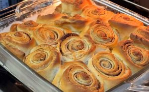 Homemade cinnamon roll dough rolled out with cinnamon filling