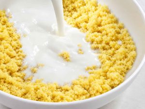 Mixing semolina and yogurt for Basbousa recipe
