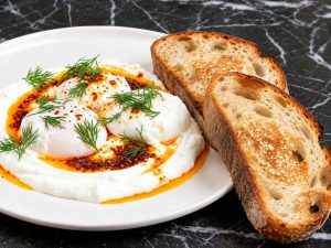 Eating Turkish Eggs with fresh bread